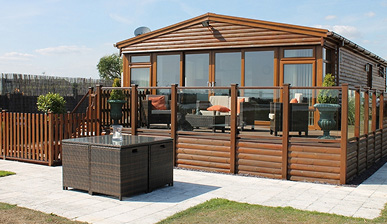 photo of log-cabin style static caravan with a patio